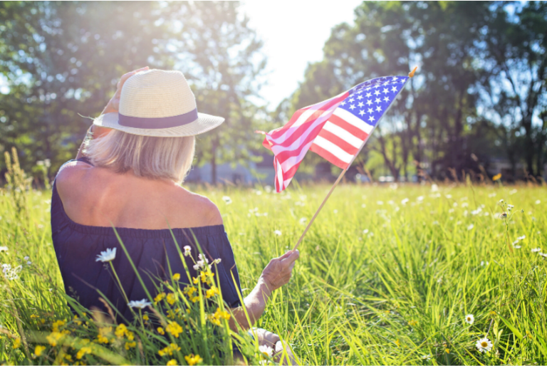 Fortunate to Live in America woman in grass waving American flag