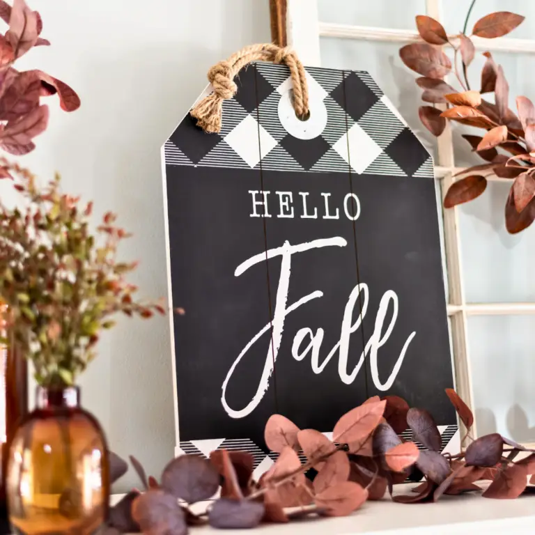 Hello Fall written on a chalkboard sign with autumn leaves around it